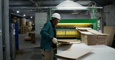 A worker at a factory making cardboard boxes video