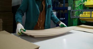 A worker in a factory with cardboard boxes video