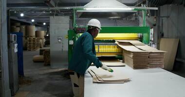 A worker at a factory making cardboard boxes video
