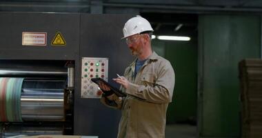 A man in a hard hat is using a tablet video