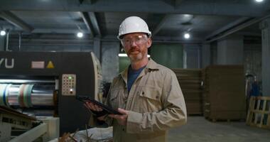 A man in a hard hat holding a tablet computer video