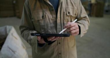 A man in a jacket is holding a pen and writing on a tablet video