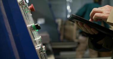 A person using a tablet computer in a factory video