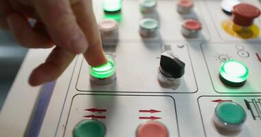 A person is pressing a button on a control panel video