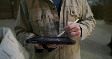 A man in a jacket is holding a tablet computer video