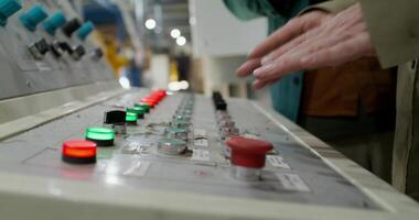 A person is touching a control panel in a factory video