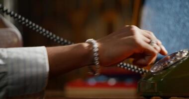 A person is holding a telephone in front of a desk video