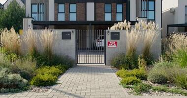 A modern home with a gate and grass video