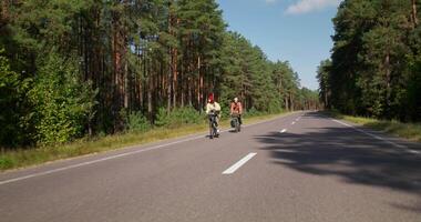 Two people riding on skateboards down the middle of an empty road video