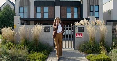 A woman standing in front of a house video