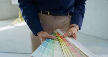 A man holding a color swatch in front of a table video