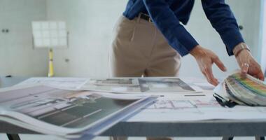 A person is standing in front of a table with some architectural plans video