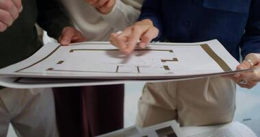 Three people looking at a blueprint on a table video