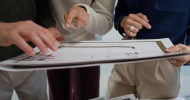 Three people looking at a blueprint on a table video