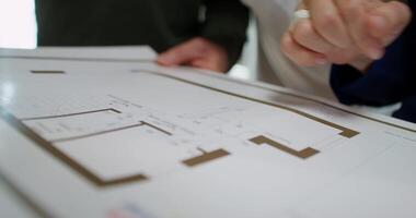 A person is looking at a blueprint on a table video