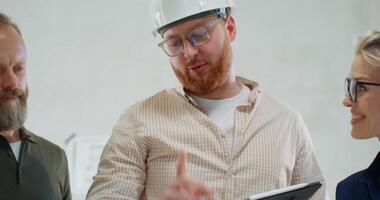 Three men in hard hats and glasses talking to each other video