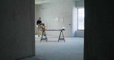 A woman standing in an empty room with a table and a ladder video