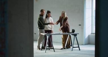 Three people shaking hands in an empty room video