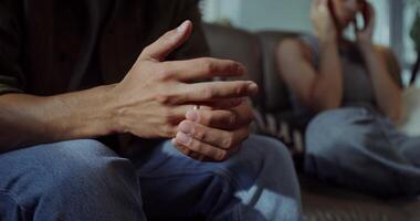 A man sitting on a couch with his hands on his lap video