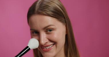 A woman is smiling while using a brush video