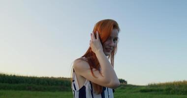 A woman with red hair standing in a field video