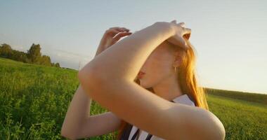 A woman is standing in a field with her hands on her head video