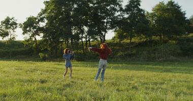 Two people standing in a field with a tree in the background video