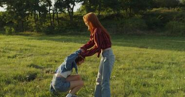 Two women in jeans and a shirt standing in a field video