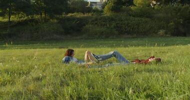 Two people laying in the grass on a hill video