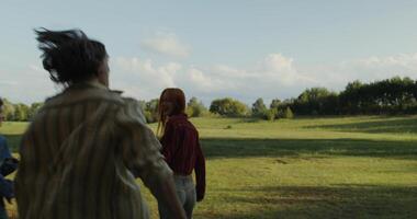 Three people walking in a field with a tree in the background video