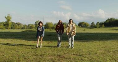 Three people standing in a field with a tree in the background video