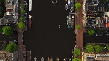 top visie van de pier met afgemeerd schepen Aan de kanaal in Amsterdam. dar beweegt langs de kanaal. Amsterdam, Nederland video