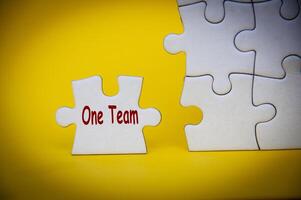 One Team text on separated jigsaw puzzle. One team and teamwork concept photo