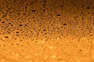 Rain droplets on a dark golden color background with customizable space for text or ideas photo