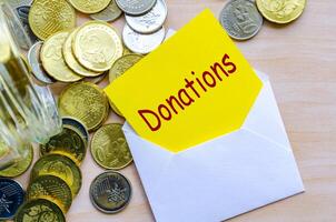 Donate Today text on yellow paper covered with white envelope photo