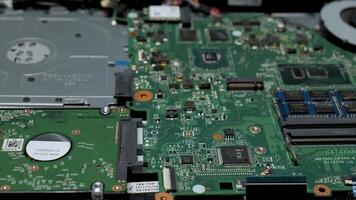 fechar-se do uma computador portátil placa mãe com componentes, detalhado Visão do uma desmontado computador portátil placa mãe mostrando circuitos, bater, e uma Difícil dirigir. video