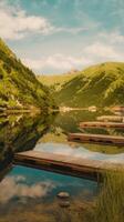 A lake with wooden docks and mountains in the background photo