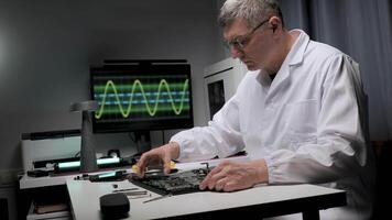 Electronics Engineer Repairing a Laptop. The background includes various electronic tools and a monitor displaying a waveform, suggesting diagnostics and troubleshooting video
