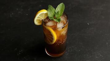 A glass of iced tea with a lemon wedge and mint photo