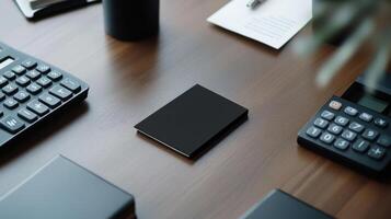 A black box sitting on a desk next to a keyboard and a calculator photo