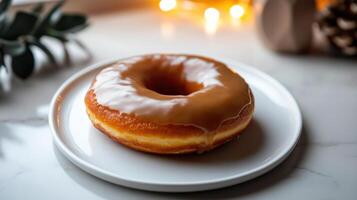fresh doughnut with caramel glaze on white plate, surrounded by warm lights photo