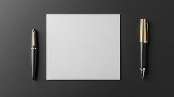 flat lay of blank note paper with two elegant pens on dark surface photo