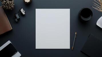 flat lay of blank sheet of white paper on dark desk with accessories photo