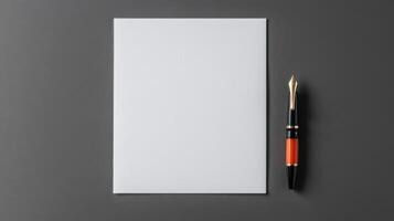 Blank white paper with pen and ink on gray background photo
