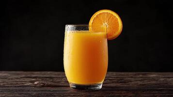 A glass of orange juice on a wooden table photo
