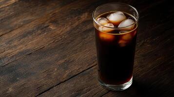 Freshly brewed cold brew coffee in clear glass with ice cubes photo