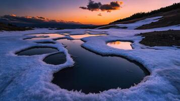 frozen landscape with pools of water reflecting sunset sky photo