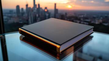 A book sits on a glass table with a city in the background photo