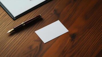 Business card on wooden desk with pen and notepad photo