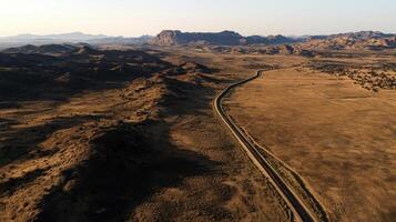 Aerial view of winding road through vast desert landscape with mountains photo